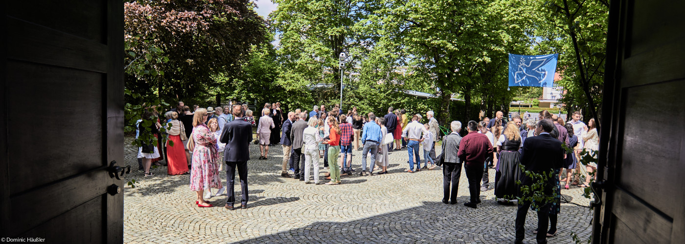 Familien bei der Konfirmation vor der Kirche